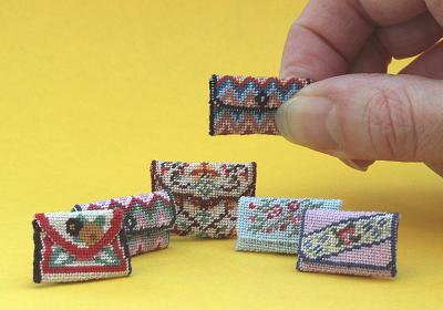 A clutch bag held in the hand and 5 other bags