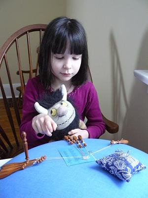 Little girl sitting doing bobbin lace
