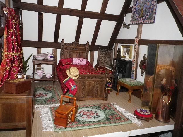 Smaller dollhouse bedroom with needlepoint handbag, carpets, wallhanging, footstool, bellpull, bolster cushion and Christmas stocking