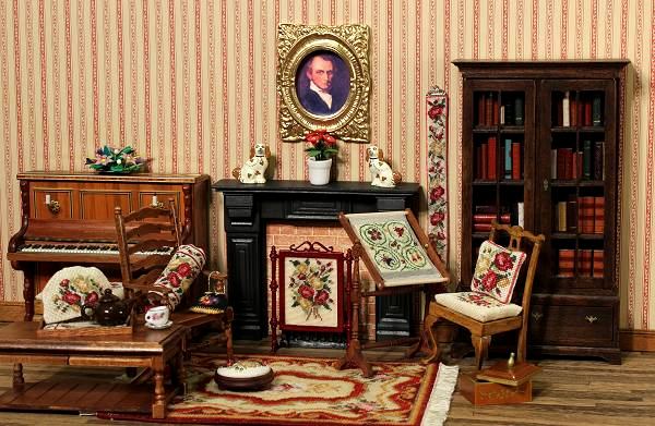 A room in a 1/12th scale dollhouse, showing a Victorian scene with many needlepoint items from the Janet Granger range of kits
