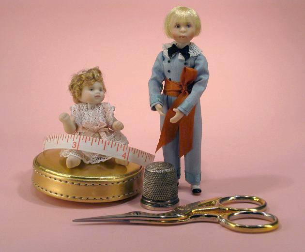 Picture of dollshouse scale dolls and sewing tools with tape measure to indicate the size of the 12th scale items