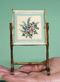 A dollhouse needlework stand on a hand