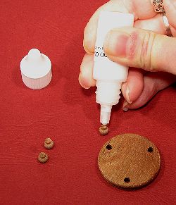 Dollhouse needlepoint tutorial - apply glue to the bun feet