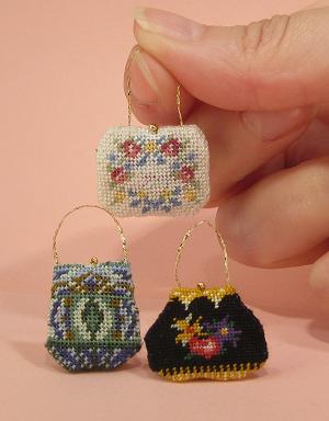 Three miniature handbags and a hand
